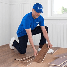 handyman installing hardwood flooring in home