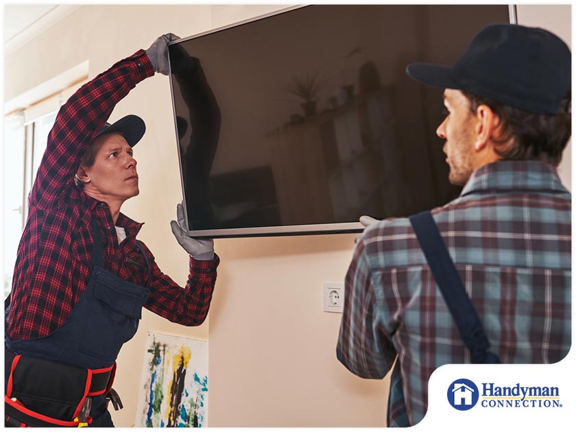 https://www.handymanconnection.net/mason/wp-content/uploads/sites/29/2021/07/2062-1623169926-handymen-installing-a-flat-screen-tv.jpg