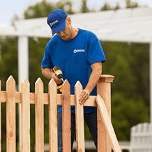 handyman installing wooden fence