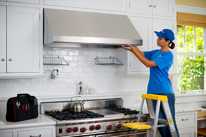 handyperson from Handyman Connection installing kitchen range hood