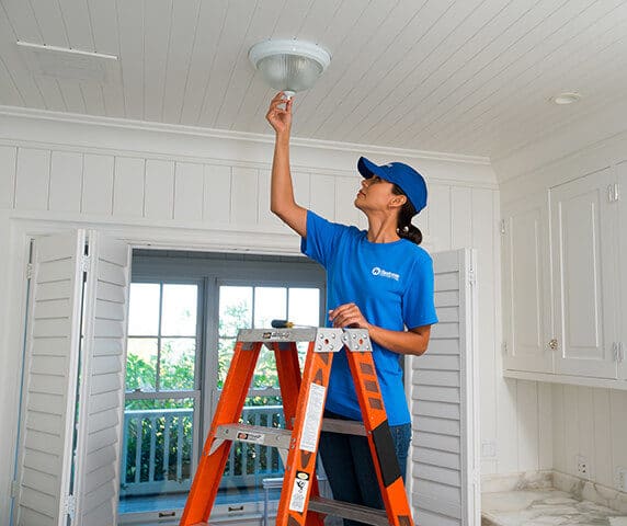 craftsperson from Handyman Connection installing electric light 