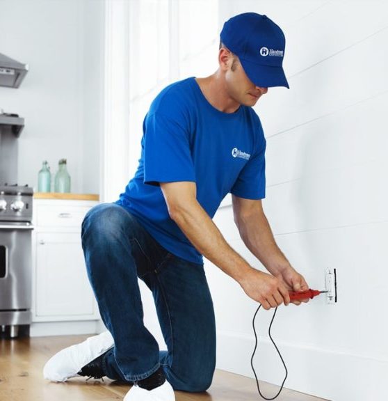 handyman inspecting electrical outlet