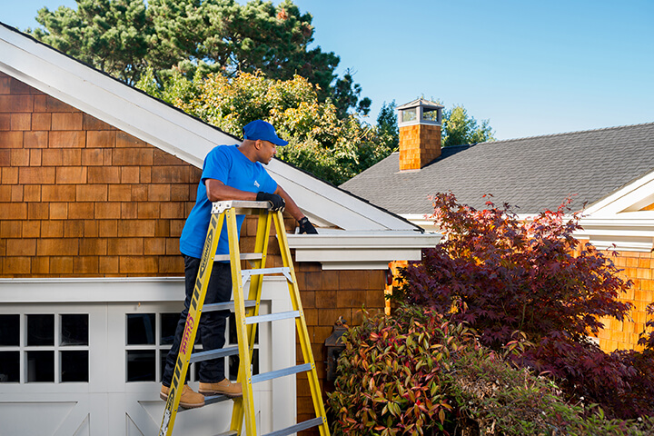 handyman inspecting gutters