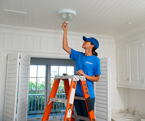 craftsperson installing light fixture