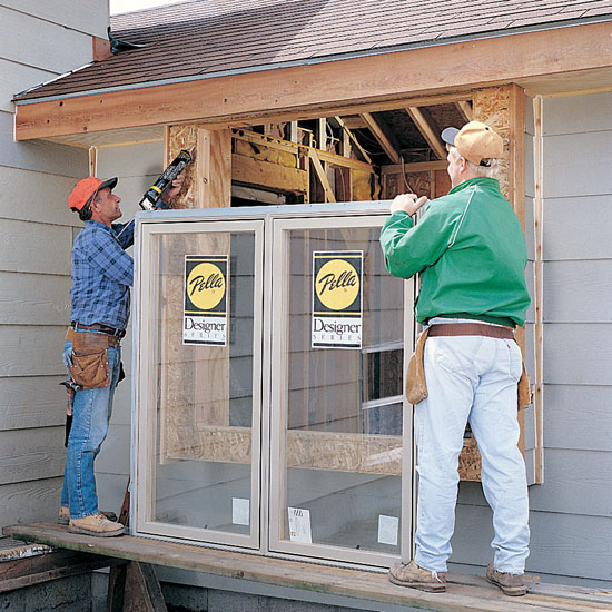 handymen from Handyman Connection installing new windows in home